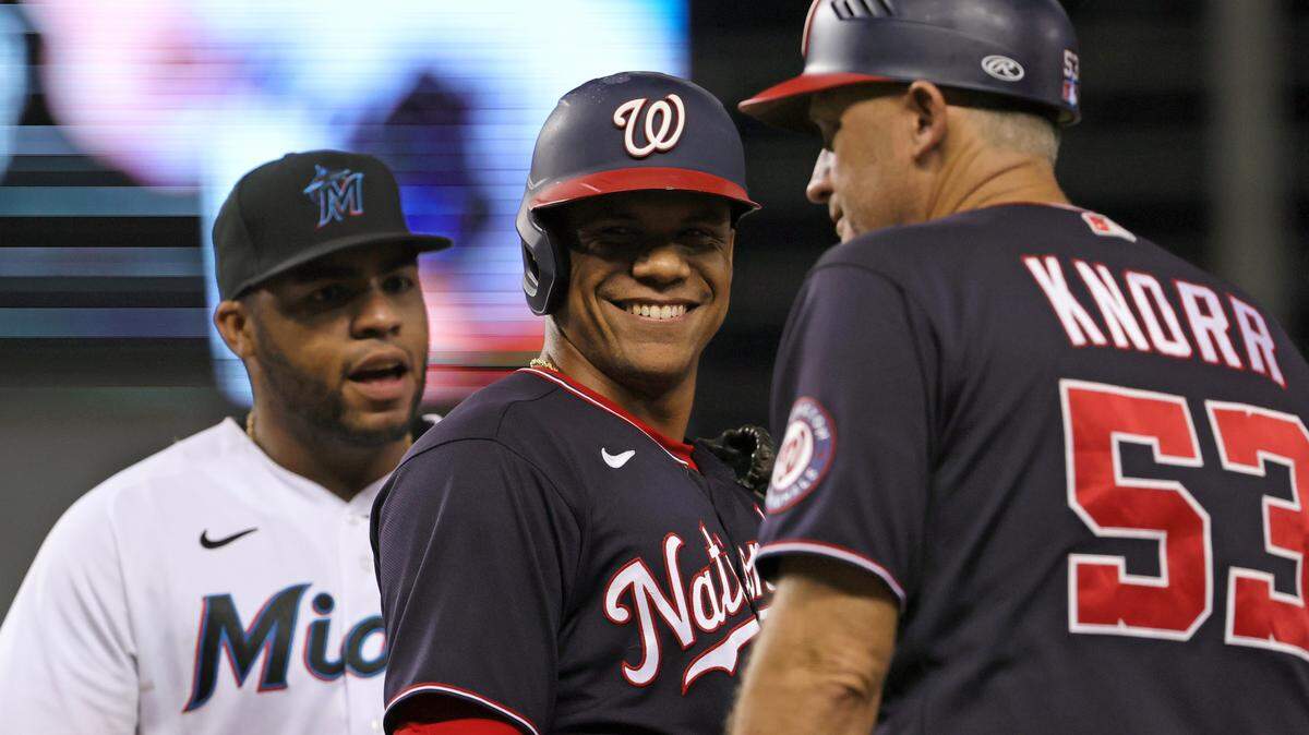 Washington Nationals right fielder Juan Soto (center) smiles as Marlins first baseman Jesus Aguilar looks during baseball game last season at loanDepot park in Miami, Florida.