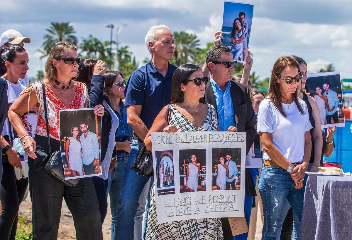 Surfside Mayor Charles Burkett, center, joined families of Surfside collapse victims as they held a press conference Thursday, Sept. 23, 2021, at the site of the Champlain Towers South Condo collapse to call for a memorial to be constructed where 98 victims died in Surfside, Florida.