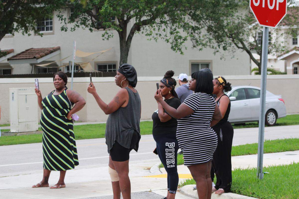 Residents watch as Miami-Dade police’s SWAT team tries to make entry into a south Miami-Dade home.