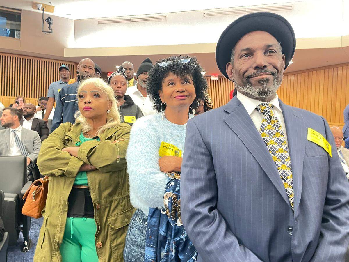 Broadway Cuthbert Harewood Jr., foreground, waits for his chance to speak in favor a proposal to add hip-hop song titles to street names in Liberty City at a Miami-Dade County Commission meeting on Tuesday, March 18, 2025. Behind him are fellow supporters Myrlie Coleman and Quashonda Oats.