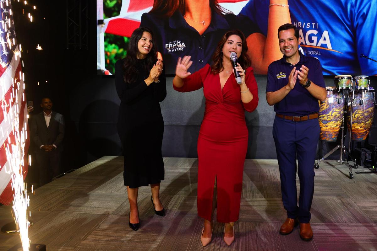 City of Doral Mayor Christi Fraga, joined by Doral City Council candidate for seat 3 Nicole Reinoso, and Doral City Council for seat 1 Rafael Pineyro, speaks to supporters after winning reelection during a victory party at Champions Sports Bar & Grill at 1360 NW 88th Ave. in Doral, Florida, Tuesday, November 5, 2024.