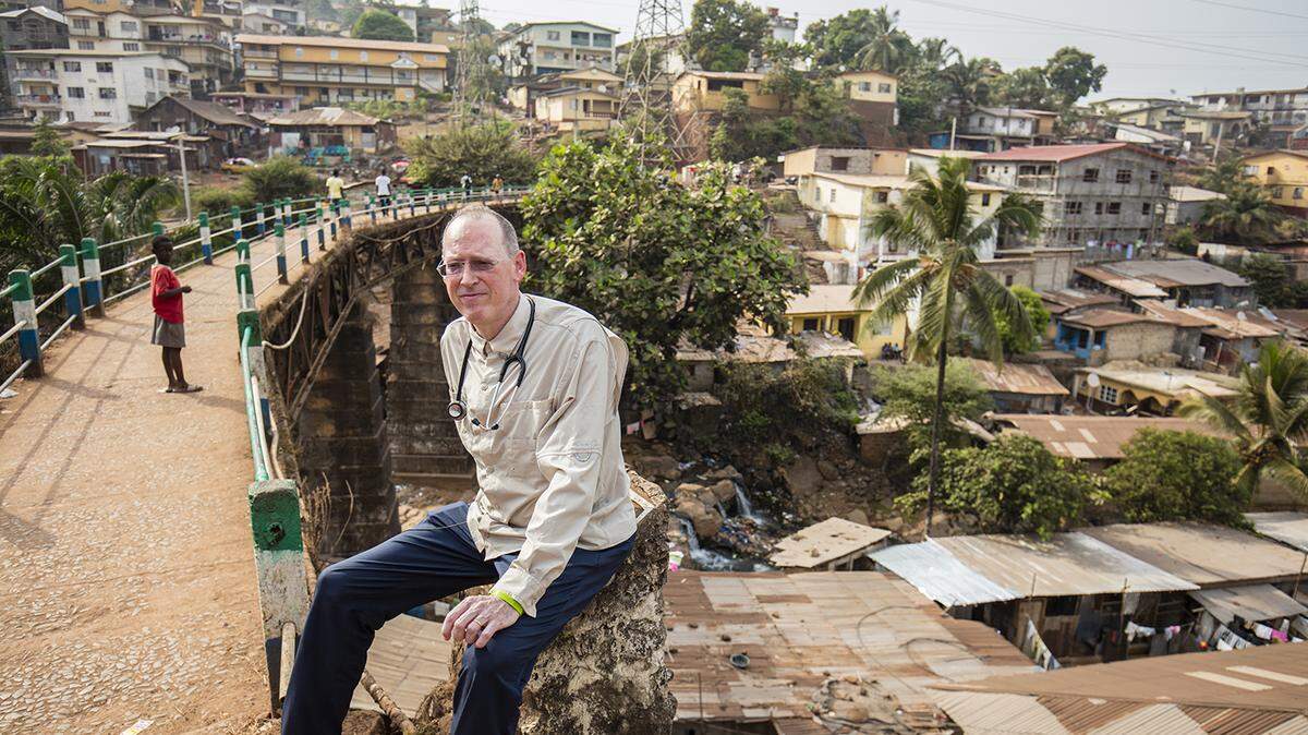 El Dr. Paul Farmer sentado junto al puente de Tengeh Town durante su visita a Freetown, Sierra Leona, el 14 de diciembre de 2015.