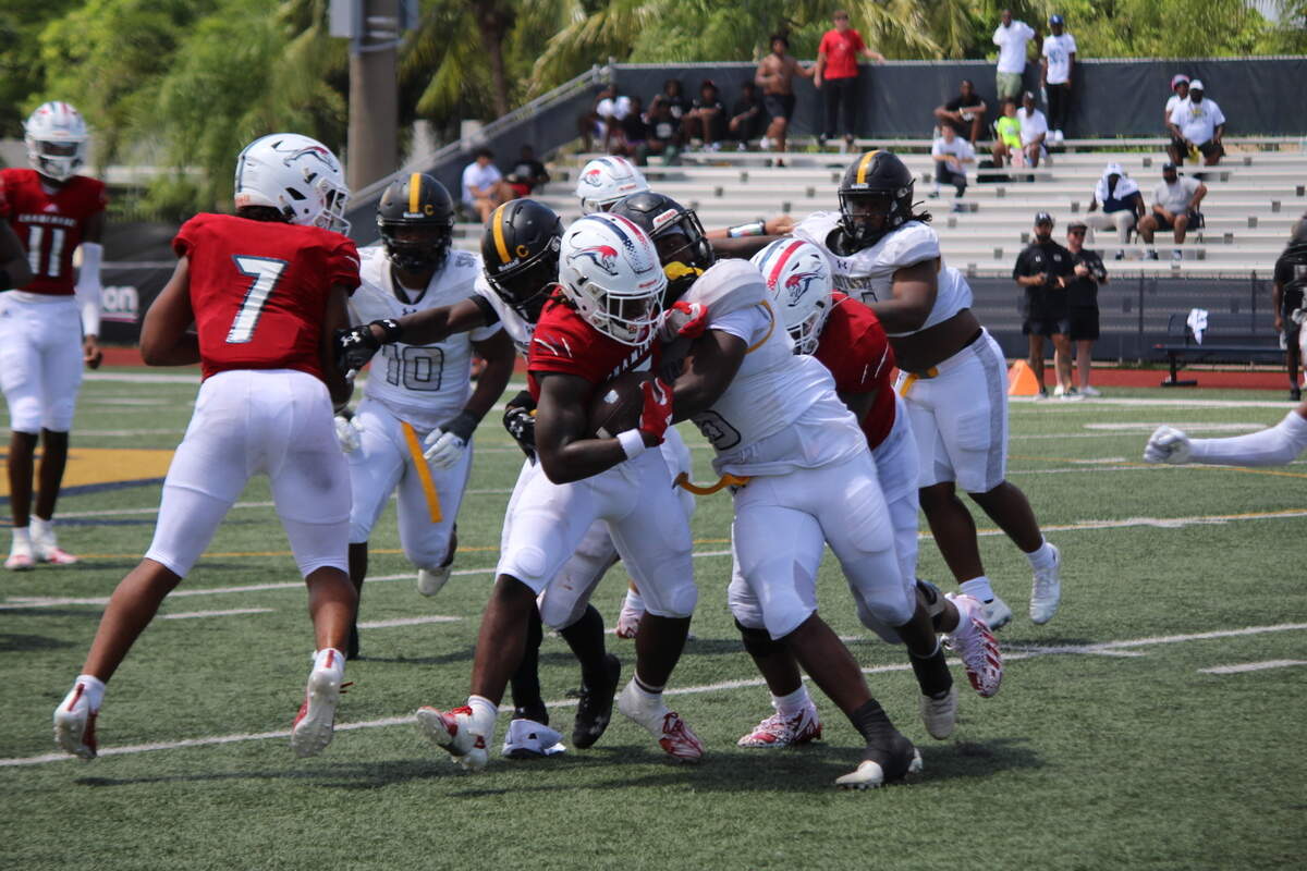 Chaminade running back Jaquri Lewis fights for extra yards during the Lions’ 35-14 victory over St. Frances Academy on Saturday at St. Thomas Aquinas.