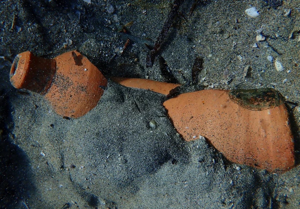 Broken jugs partially embedded in the sand