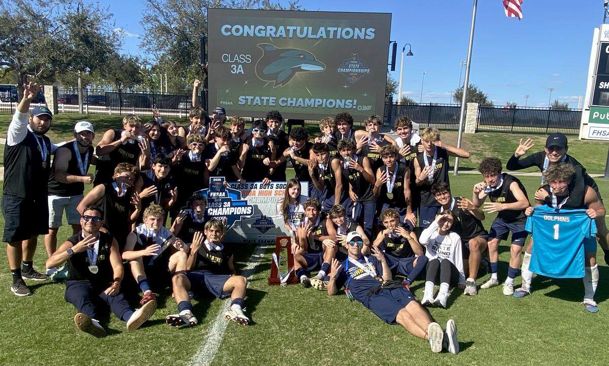 Downtown Doral players celebrate after winning the FHSAA Class 3A boys soccer state championship trophy on Saturday at Lake Myrtle Soccer Complex in Auburndale.