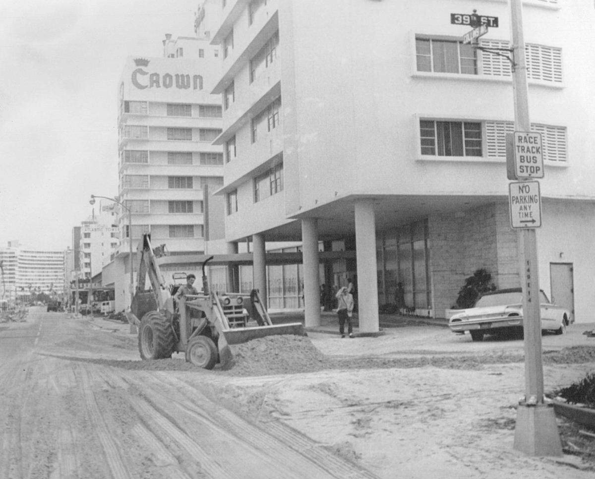 Workers pushes sand off Miami Beach's Collins Ave. at 39th Street after Hurricane Inez in 1966.