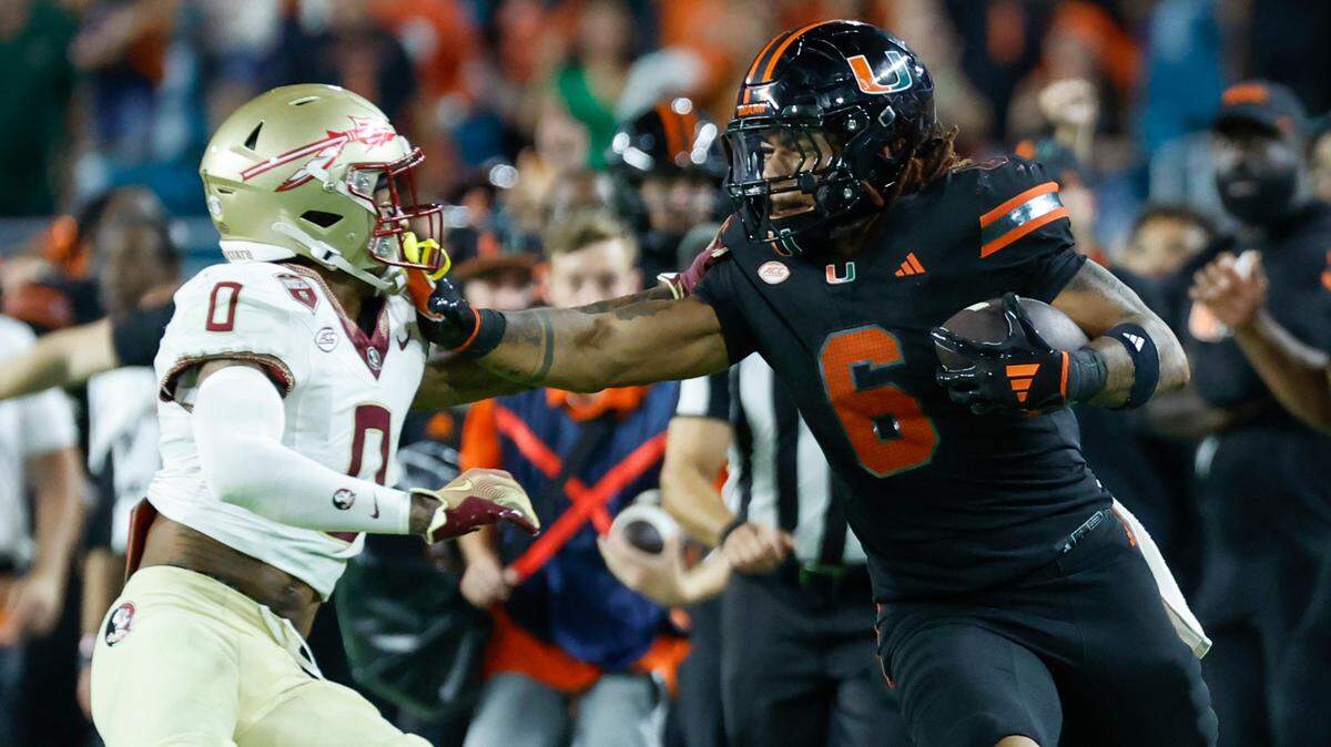 Miami Hurricanes running back Damien Martinez (6) stiff arms Florida State Seminoles defensive back Earl Little Jr. (0) in the second half during an NCAA football game at Hard Rock Stadium in Miami Garden, Florida on Saturday, October 26, 2024.