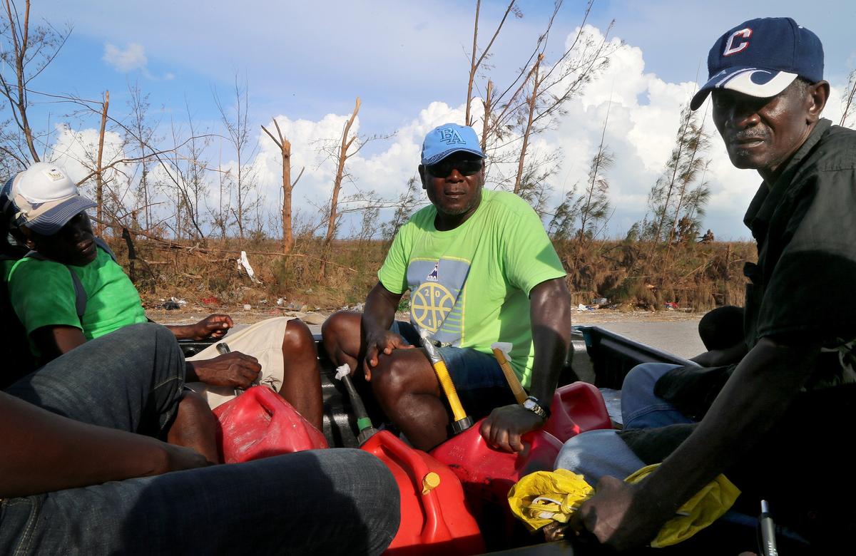 A group of Haitian men searching for fuel stopped in front of the New Haitian Mission Baptist Church in Treasure Cay, which was used as a shelter as Hurricane Dorian pounded the Abacos over the Labor Day weekend. They are among those vowing to stay.