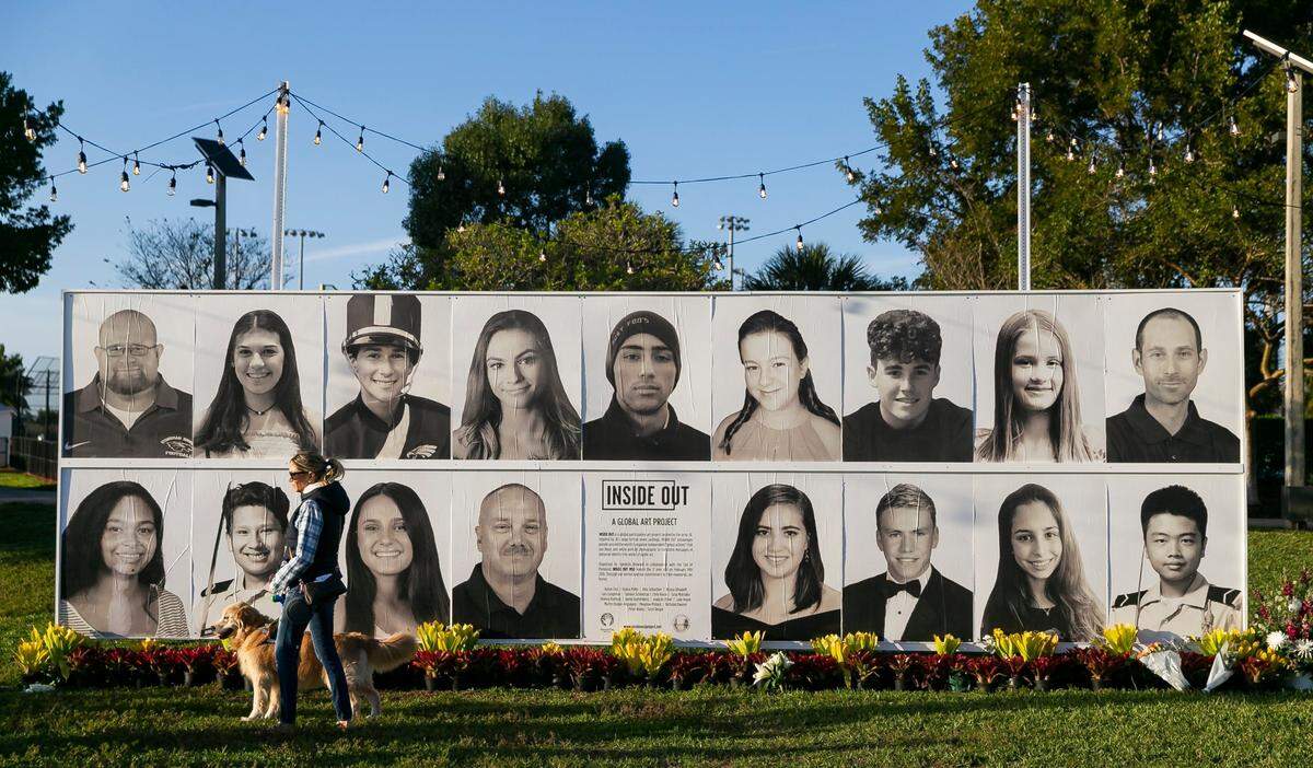 Ali Dangelo and her service dog, Strudel, attend a community commemoration event for the Marjory Stoneman Douglas High School victims at Pine Trails Park in Parkland, Florida on Monday, Feb. 14, 2022. The event was held on the 4-year anniversary of the shooting and included therapy dogs on-site, a memory wall displaying photos of the victims, an area to write messages, a brief commemoration ceremony, a video honoring the victims and a drum circle.