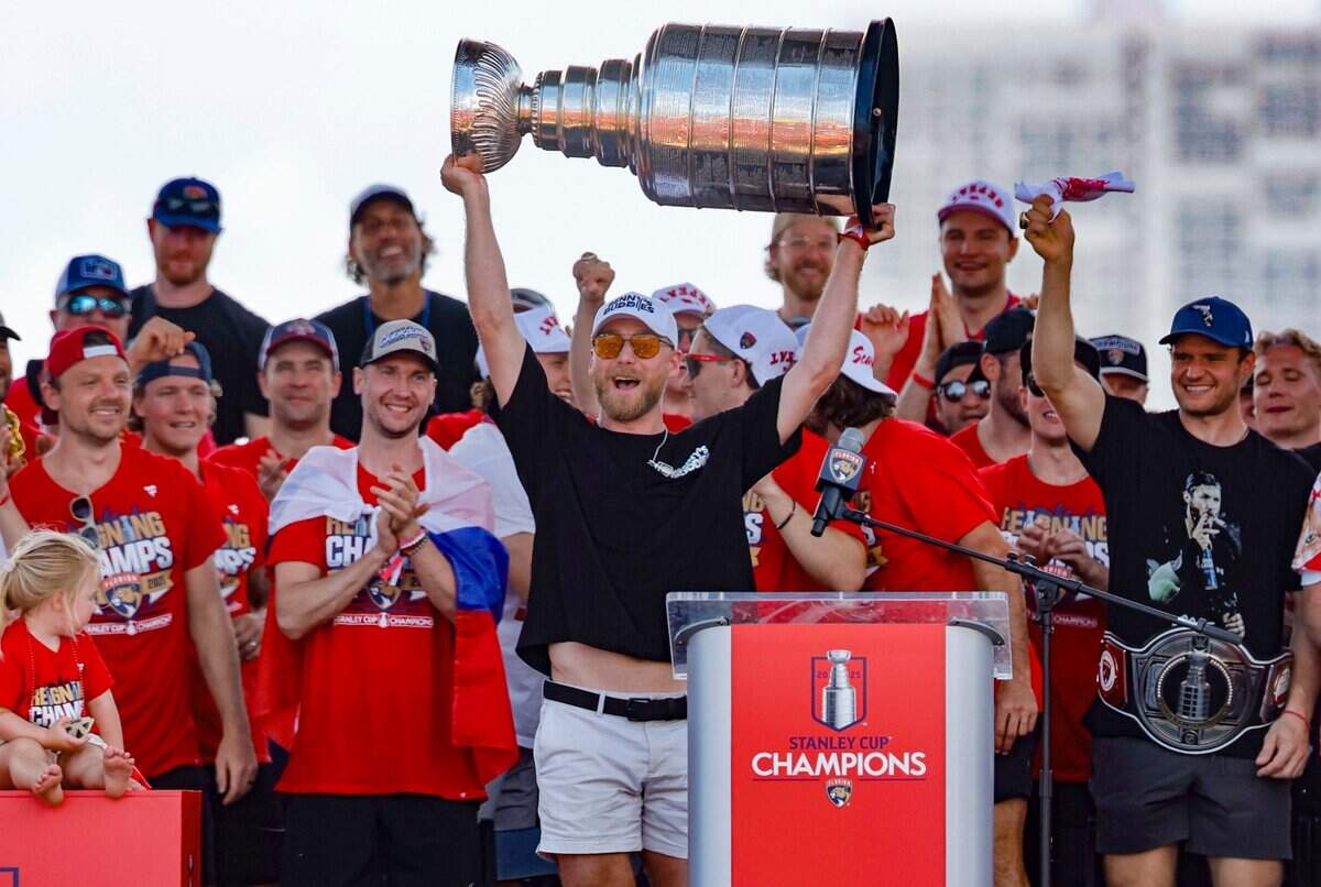 Florida Panthers center Sam Bennett (9) hoists the Stanley Cup as teammates celebrate on stage during the team’s victory parade and rally along A1A in Fort Lauderdale, Florida, on Sunday, June 22, 2025