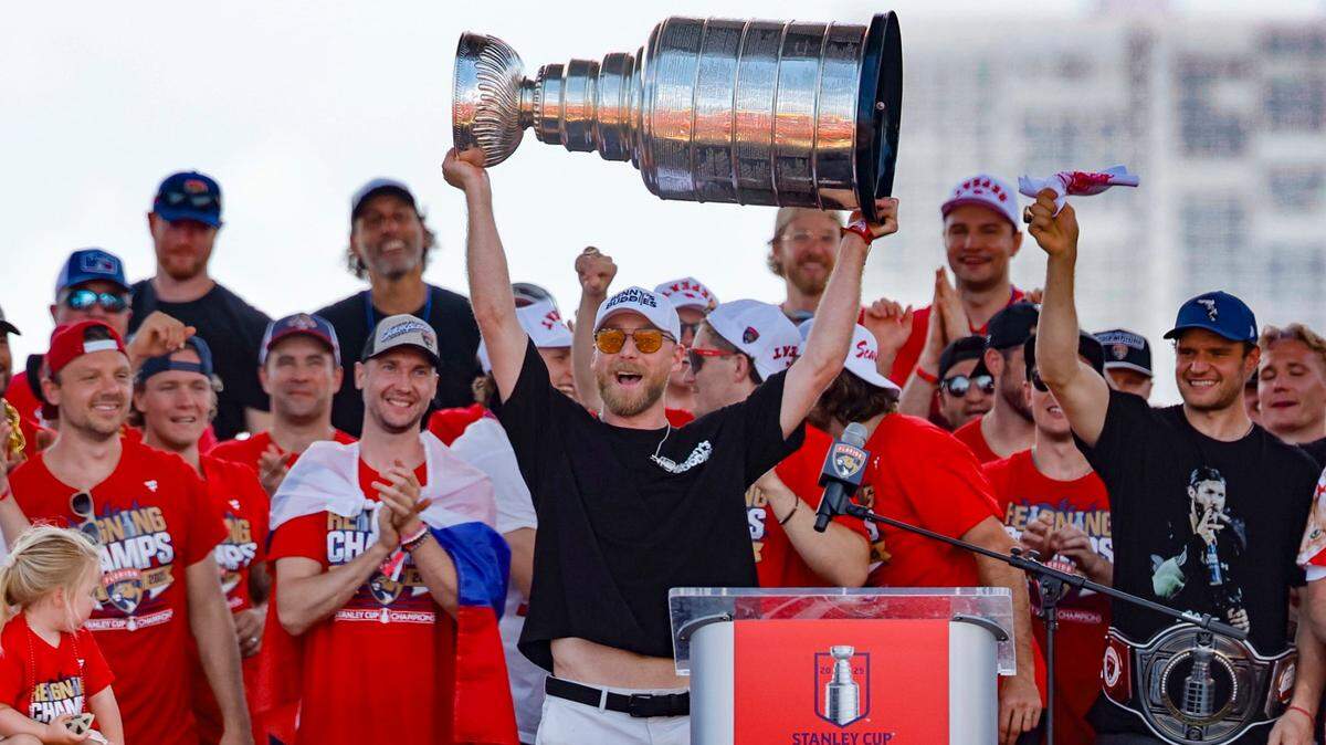 Florida Panthers center Sam Bennett (9) hoists the Stanley Cup as teammates celebrate on stage during the team’s victory parade and rally along A1A in Fort Lauderdale, Florida, on Sunday, June 22, 2025