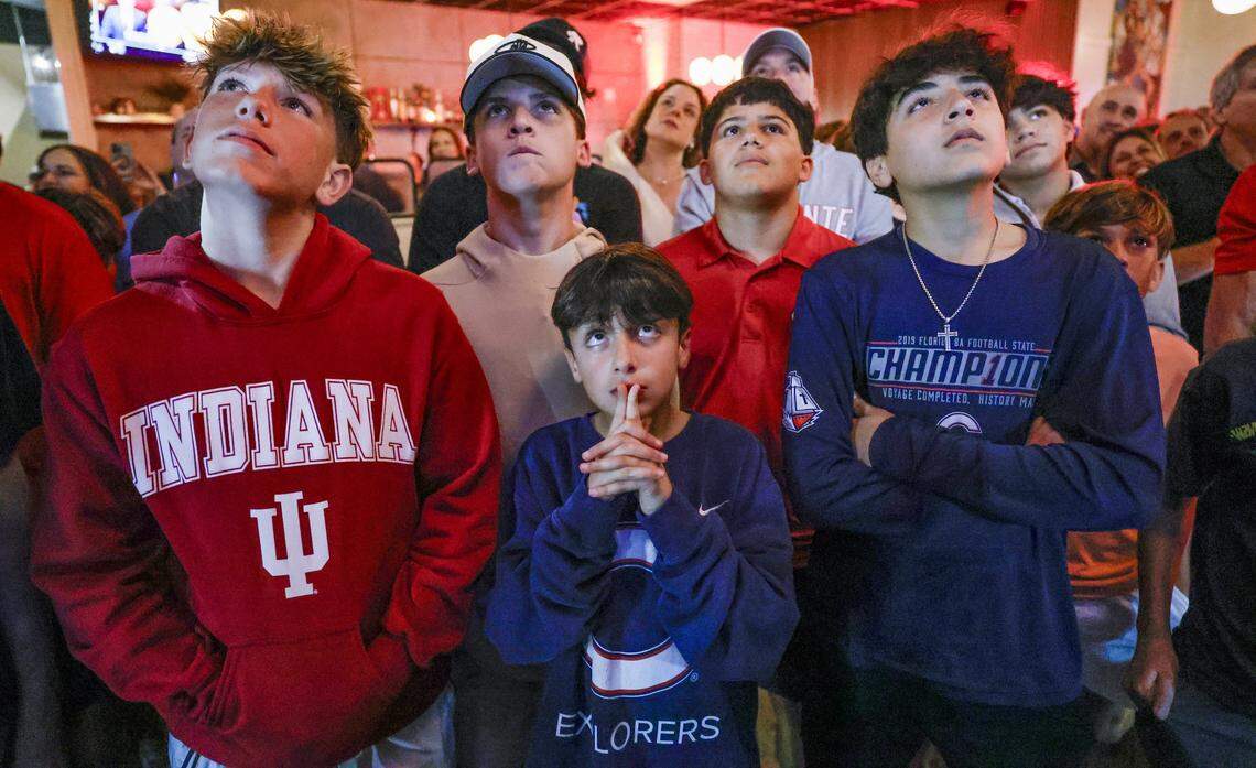 Massimo Andreu, 8, a fan of Indiana Hoosiers quarterback Fernando Mendoza, stands at center and waits in anticipation during a watch party for the announcement that Mendoza, a Christopher Columbus High School alumnus, has won the Heisman Trophy. Family, friends and Columbus alumni gathered to watch the announcement at Vice Pizza in South Miami, Florida, on Saturday, December 13, 2025. 