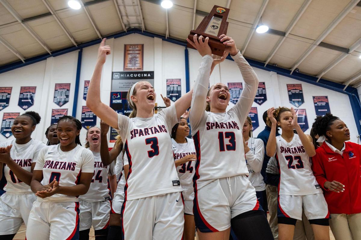 Miami Country Day players react with the trophy after defeating Westminster Academy 55-39 during the Region 4-3A girls basketball final in Miami, Florida, on Friday, February 17, 2023.