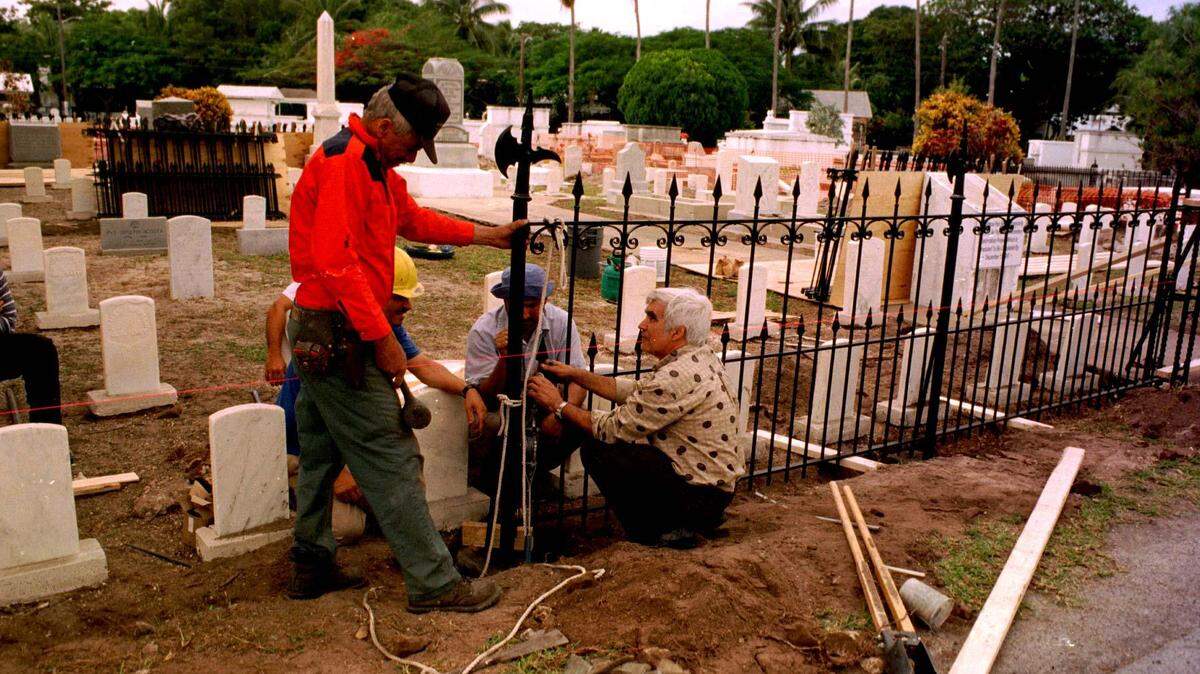 A crew from El Arte Ironworks of Hialeah works on reinstalling the cast iron fence around the U.S.S. Maine Memorial at Key West Cemetery. The fence was restored for the centennial of the sinking of the Maine.