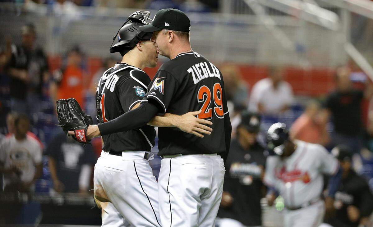 Marlins catcher J.T. Realmuto and pitcher Brad Ziegler celebrate their 6-3 victory against the Atlanta Braves game at Marlins Park, Friday, May 11, 2018.