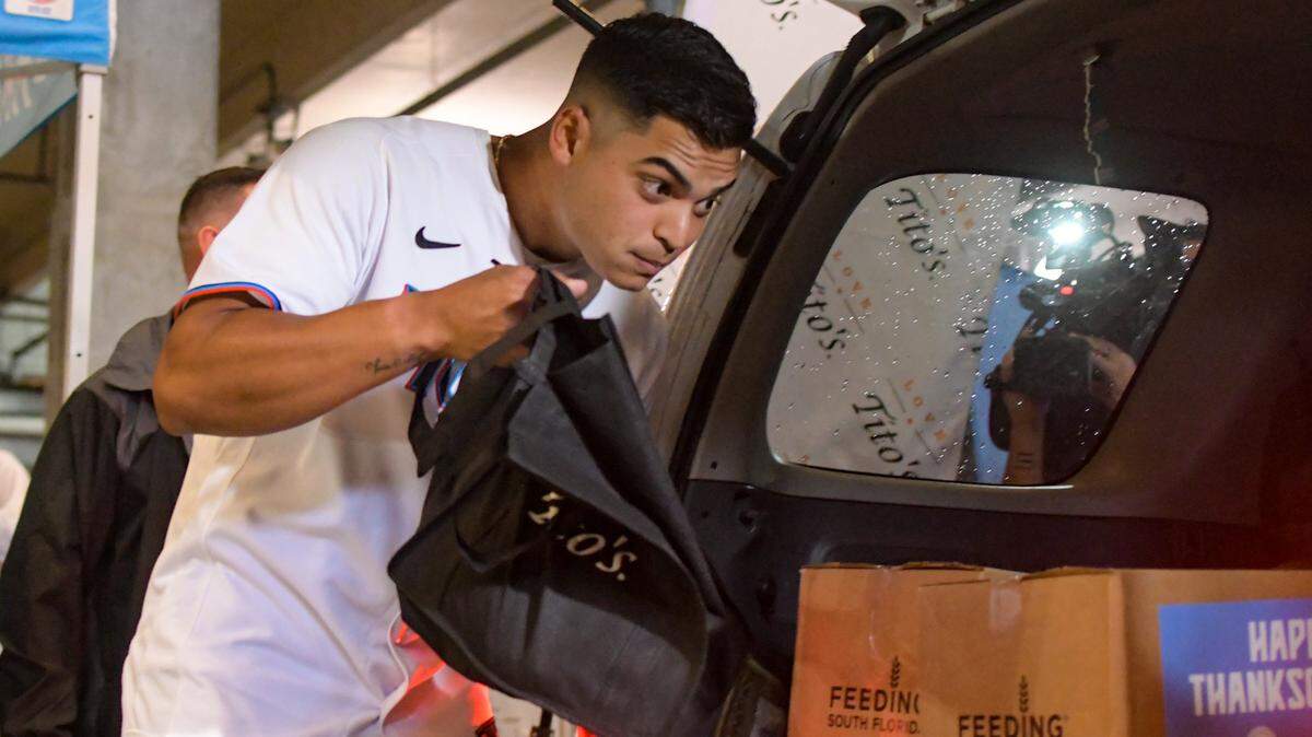 Miami Marlins left-handed pitcher Jesus Luzardo packs a Thanksgiving meal into the trunk of a car during the Marlins’ annual Thanksgiving food distribution on Friday, Nov. 19, 2021.