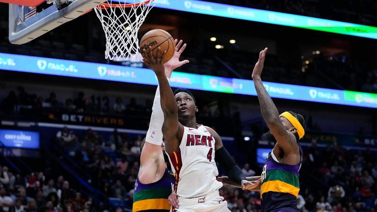 Miami Heat guard Victor Oladipo (4) goes to the basket between New Orleans Pelicans forward Naji Marshall, right, and center Jonas Valanciunas in the second half of an NBA basketball game in New Orleans, Wednesday, Jan. 18, 2023.