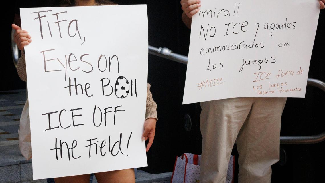 Dos personas protestan contra las redadas migratorias de la Policía de Inmigracion (ICE), durante una conferencia de prensa sobre la organización de la Copa Mundial de Fútbol FIFA 2026, el lunes 30 de junio de 2025, en Coral Gables, Florida.