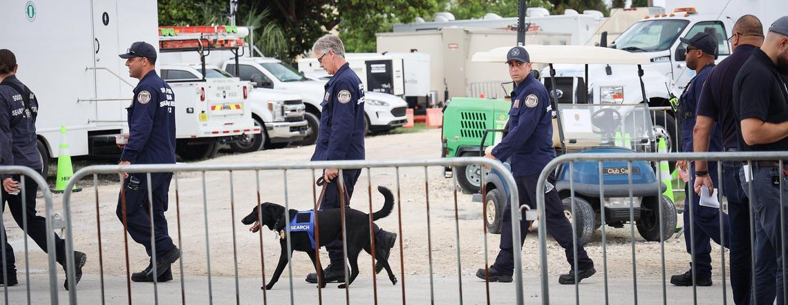 Members of the South Florida Urban Search and Rescue (FL-TF2) walk between the Miami-Dade County operation and media centers during the morning press conference. Miami-Dade and Surfside mayors updated the media on the overnight and daily operational details on Sunday, July 11, 2021, while announcing 90 people have been confirmed dead due to the Champlain Towers South collapse in Surfside.
