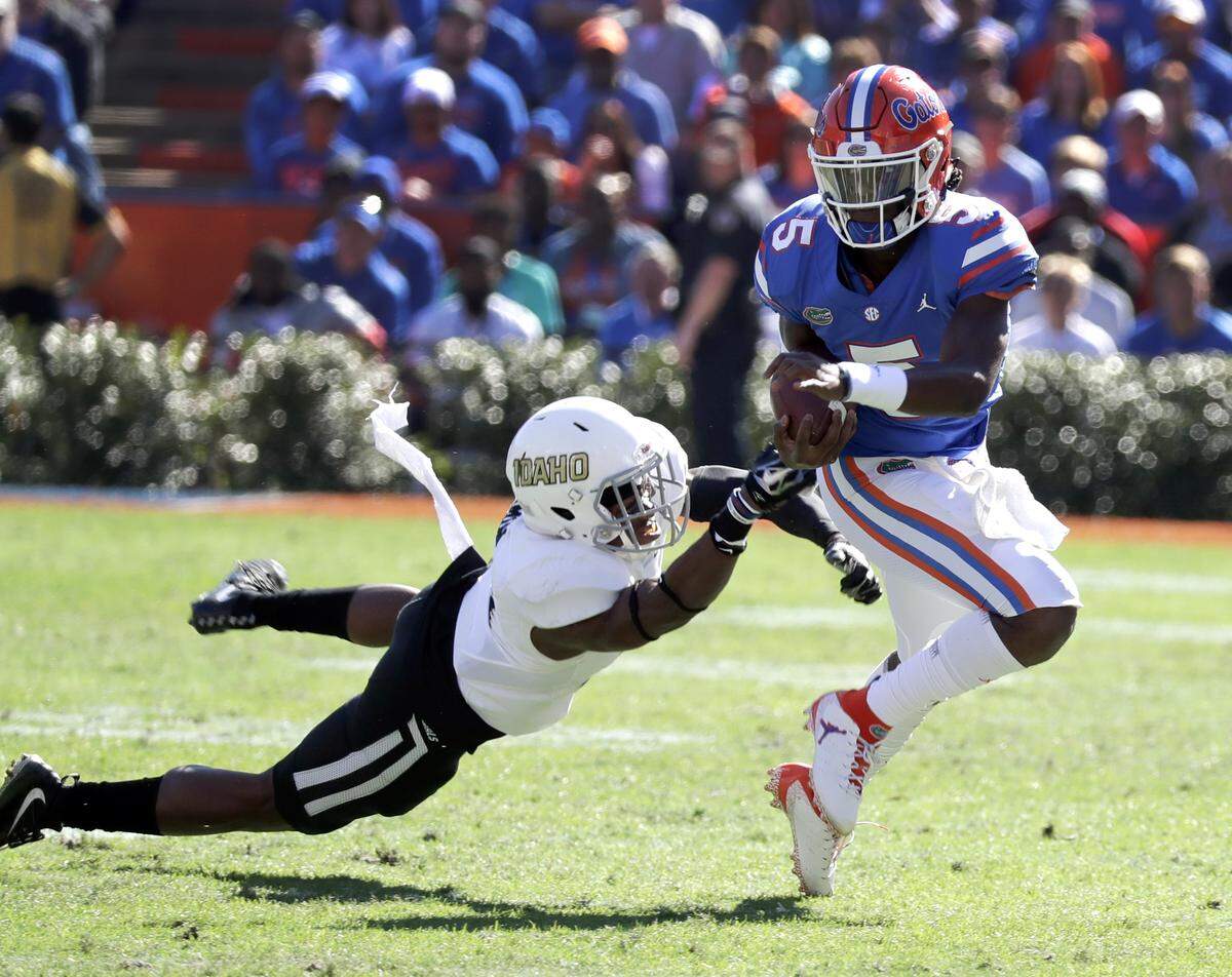 Florida quarterback Emory Jones, right, scrambles from the pocket as he tries to get past Idaho defensive back Tyrese Dedmon, left, during the first half of an NCAA college football game, Saturday, Nov. 17, 2018, in Gainesville, Fla.