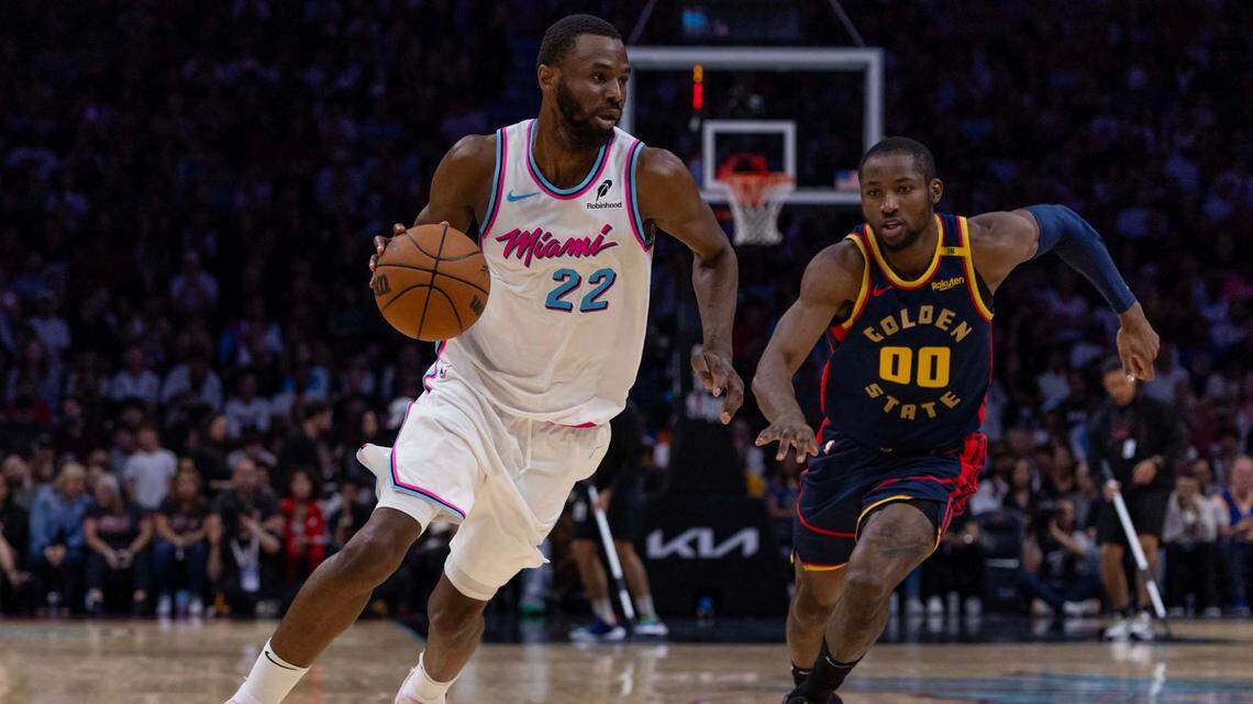 Miami Heat forward Andrew Wiggins (22) dribbles past Golden State Warriors forward Jonathan Kuminga (00) during the second half of an NBA game at Kaseya Center on March 25, 2025, in Miami.