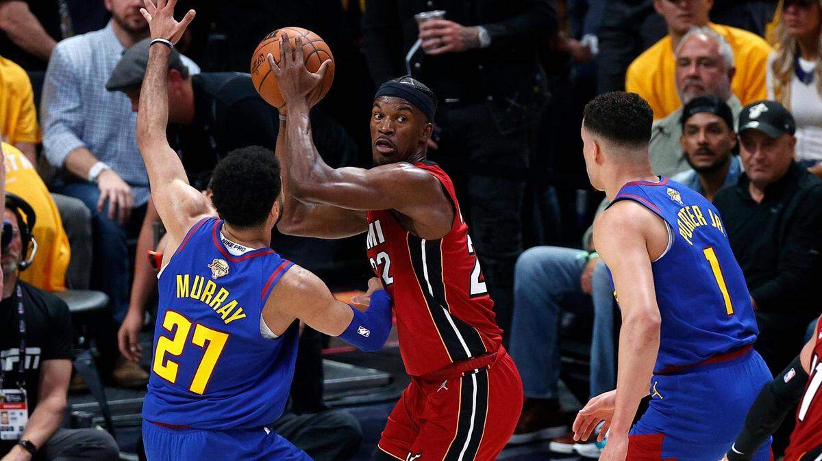 Miami Heat forward Jimmy Butler (22) controls the ball while defended by Denver Nuggets guard Jamal Murray (27) during the second quarter in game one of the 2023 NBA Finals at Ball Arena.