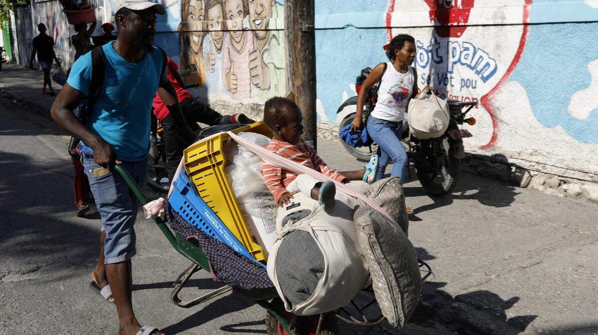 Residents flee their homes during clashes between police and gang members in Port-au-Prince, Haiti, on Saturday, March 9, 2024. (AP Photo/Odelyn Joseph)