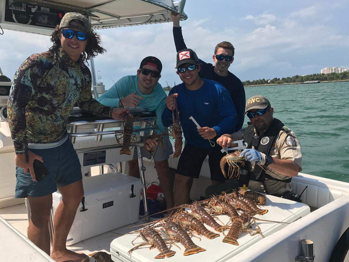 Pablo Guerra, Julian Guerra, Chris Cruanyas, Nicholas Novo and Florida Fish and Wildlife Conservation Commission Officer Guillermo Cartaya pose with lobsters the young men caught in Biscayne Bay Wednesday, July 25, 2018, the first full day of lobster miniseason.