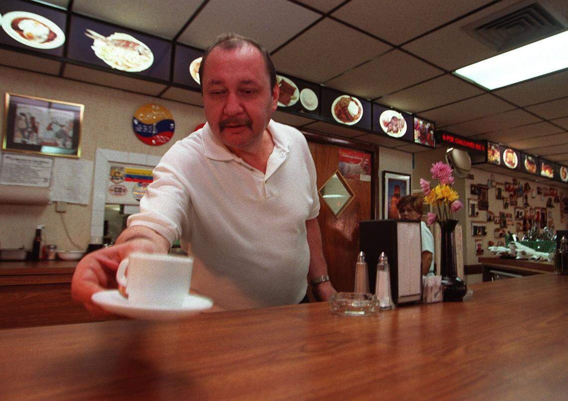 Waiter Guillermo Leon Valencia serves a cup of coffee to a customer at Colombian Monserrate Restaurant in Miami.