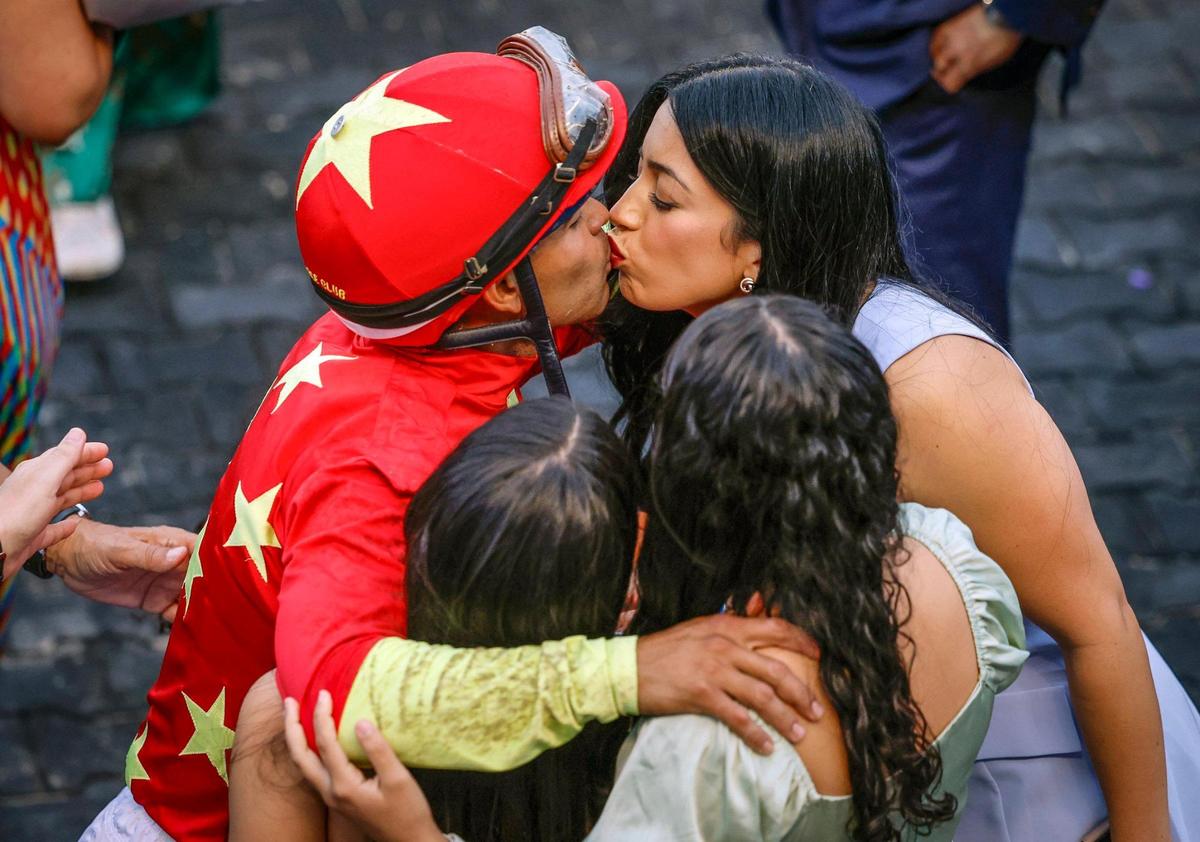 Jockey Luis Saez kisses his wife Andrea Saez as he hugs his children after riding Tappan Street to win the 74th Running of The Curlin Florida Derby at Gulfstream Park in Hallandale Beach, Florida, on Saturday, March 29, 2025.