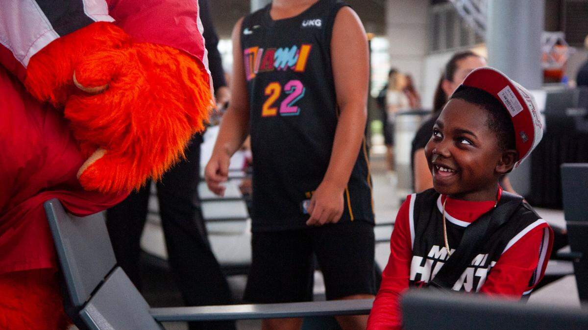 Daniel Clark, 6, smiles up at Burnie during the 2023 Miami Heat Draft Watch Party at Kaseya Stadium on Thursday, June 22, 2023 in Miami, Florida. When asked if he had a favorite Heat player, Clark responded, “All of them.”