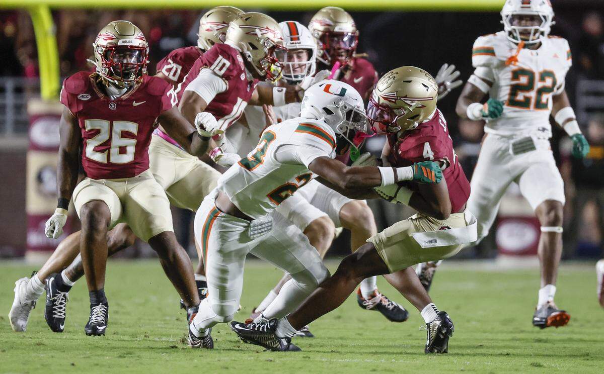 Miami Hurricanes defensive back Dylan Day (23) tackles Florida State Seminoles wide receiver Squirrel White (4) during the second half of their NCAA game at Doak Campbell Stadium in Tallahassee, Florida, on Saturday, October 4, 2025.