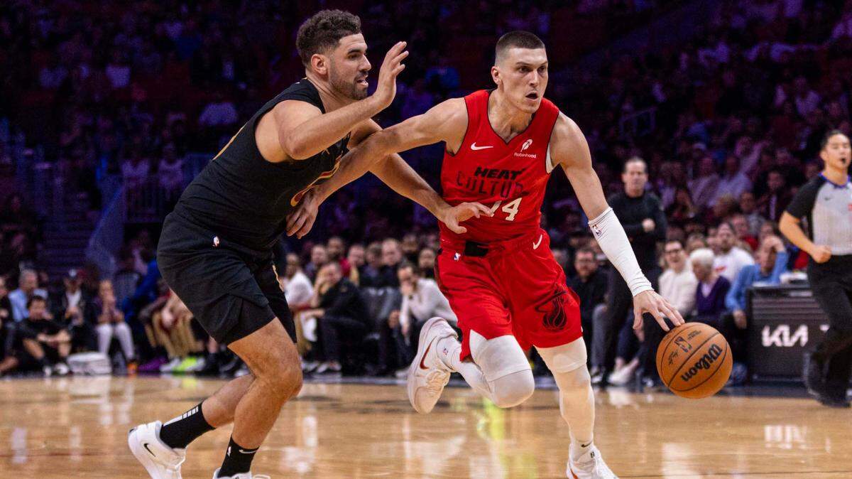 Miami Heat guard Tyler Herro (14) dribbles past Cleveland Cavaliers forward Georges Niang (20) during the second half of an NBA game at Kaseya Center on Dec. 8, 2024, in Miami.