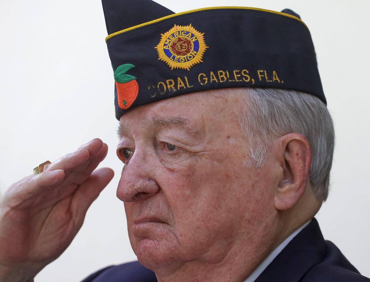 Korean War veteran Army Col. John Thomson stands at attention as “Taps” is played by trumpeter Zaq Davis.