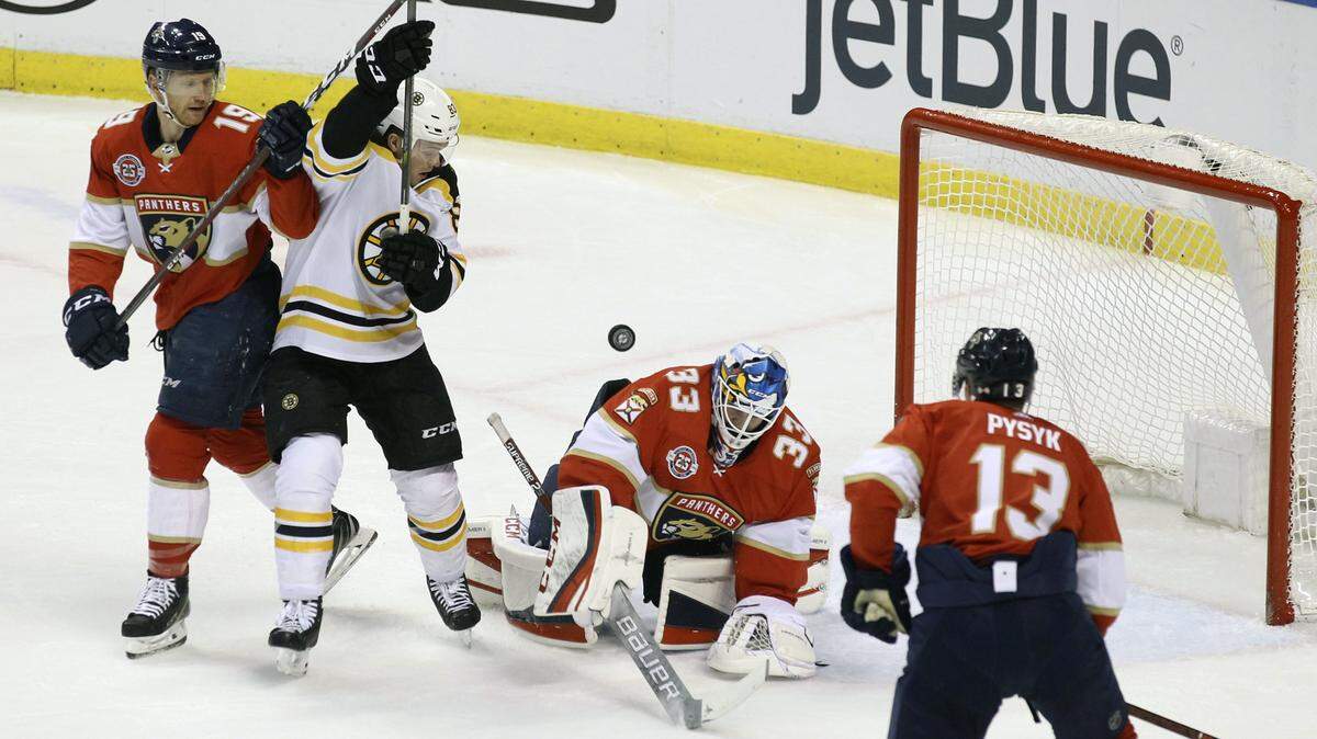 Boston Bruins’ Karson Kuhlman, second from left, looks for the puck as Florida Panthers goalkeeper Sam Montembeault (33), Mike Matheson, left, and Mark Pysyk (13) defend during the first period of an NHL hockey game, Saturday, March 23, 2019, in Sunrise, Fla. The Bruins won 7-3. (AP Photo/Luis M. Alvarez)