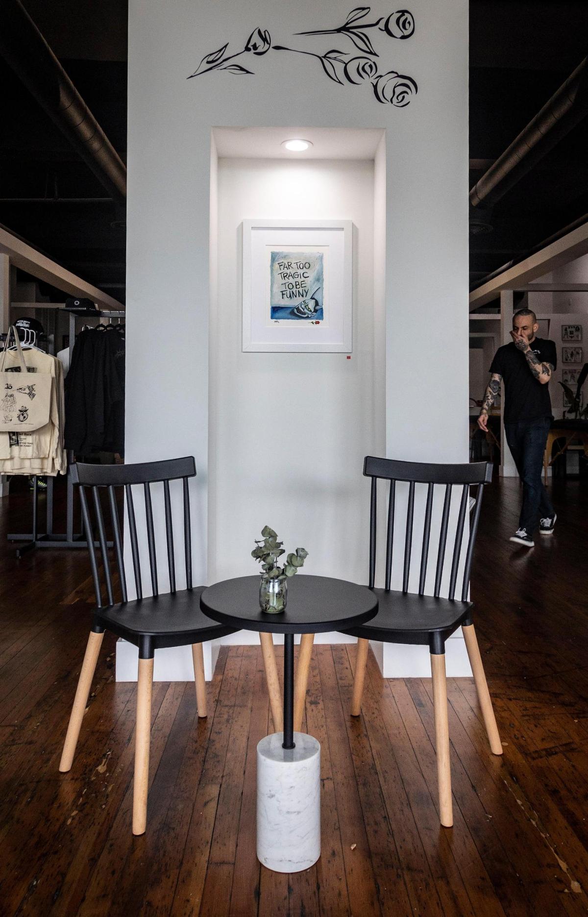 A small table at the entrance to Ocho Placas tattoo parlor in the White Rose Coffee shop.