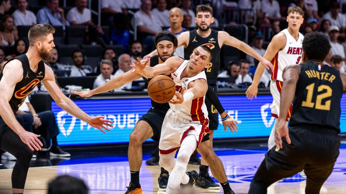 Miami Heat guard Tyler Herro (14) attempts to grab a pass by guard Pelle Larsson (9) while pressed by Cleveland Cavaliers guard Max Strus (1) and guard Luke Travers (33) during the first half of Game 3 of the NBA Playoffs at Kaseya Center on April 26, 2025, in Miami.