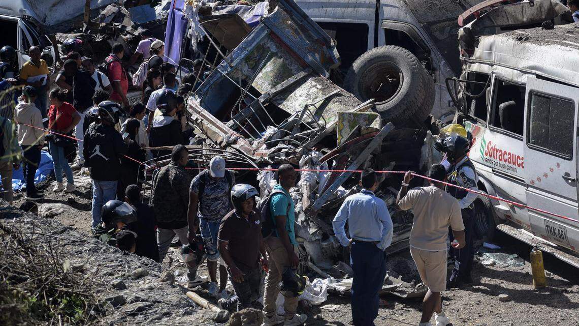Personas permanecen junto a vehículos destruidos por un ataque con bomba en El Túnel, en la carretera Popayán-Cali, en Cajibío, departamento del Cauca, Colombia, el 25 de abril de 2026.