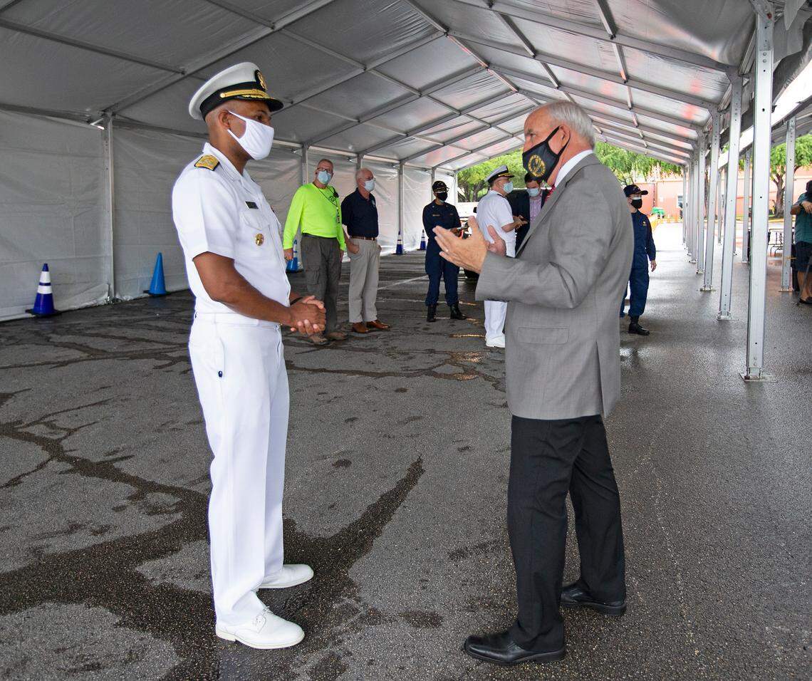 Vice Admiral Jerome Adams, the U.S. Surgeon General, talks with Miami-Dade County Mayor Carlos Gimenez at the COVID-19 drive-thru testing center at Miami-Dade County Auditorium in Miami on Thursday, July 23, 2020.