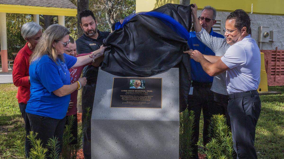 A group of elected officials, including Hollywood Mayor Josh Levy, far right, joined Debra Hixon, left, and her family members during the dedication ceremony for the Chris Hixon Memorial Trail at Stan Goldman Memorial Park on Wednesday, February 11, 2026. Debra Hixon, who is a Broward County School Board member, was married to Chris Hixon, who was one of the 17 people killed at Marjory Stoneman Douglas Senior High School on Feb. 14, 2018, in Parkland. 