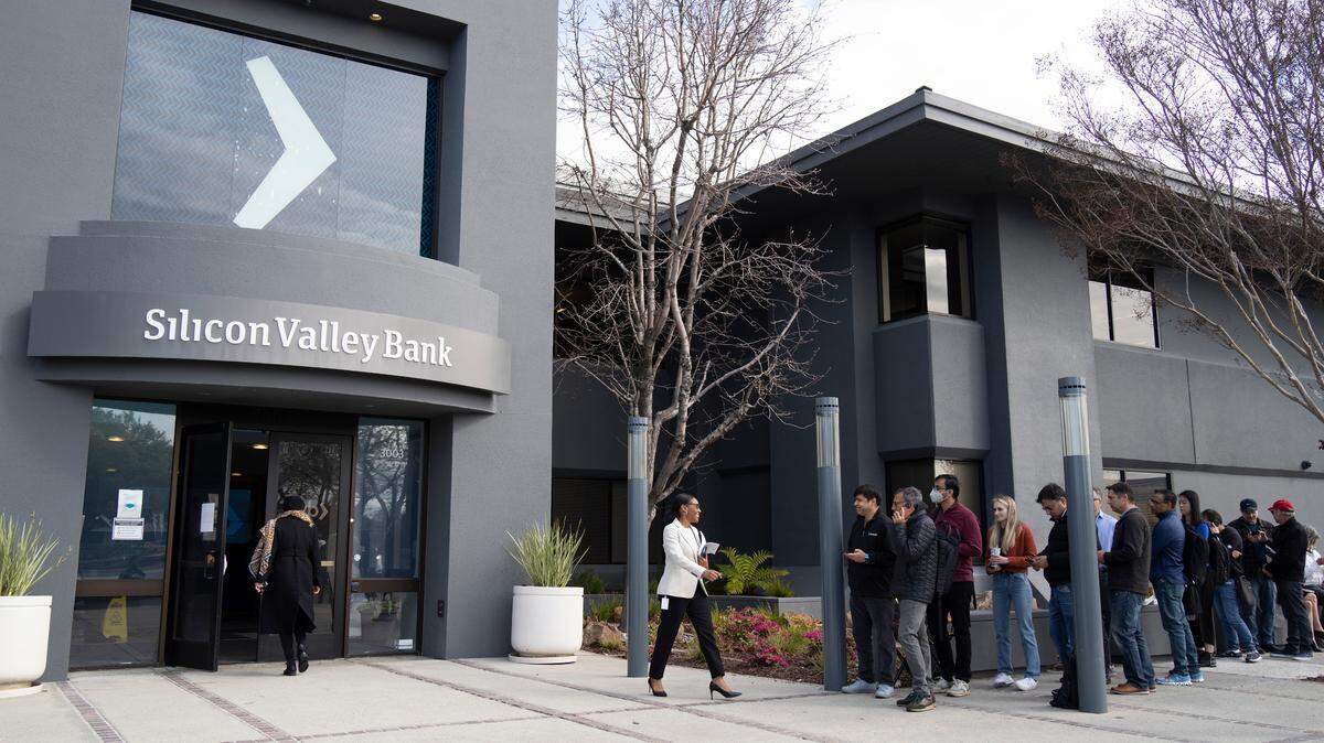 People queue up outside the headquarters of Silicon Valley Bank in Santa Clara, California, a few days after the March 10, 2023, collapse of the bank that catered to tech startups. The U.S. Treasury Department, the Federal Reserve, and the Federal Deposit Insurance Corporation took action to stabilize the U.S. banking system in response to the bank's failure. 