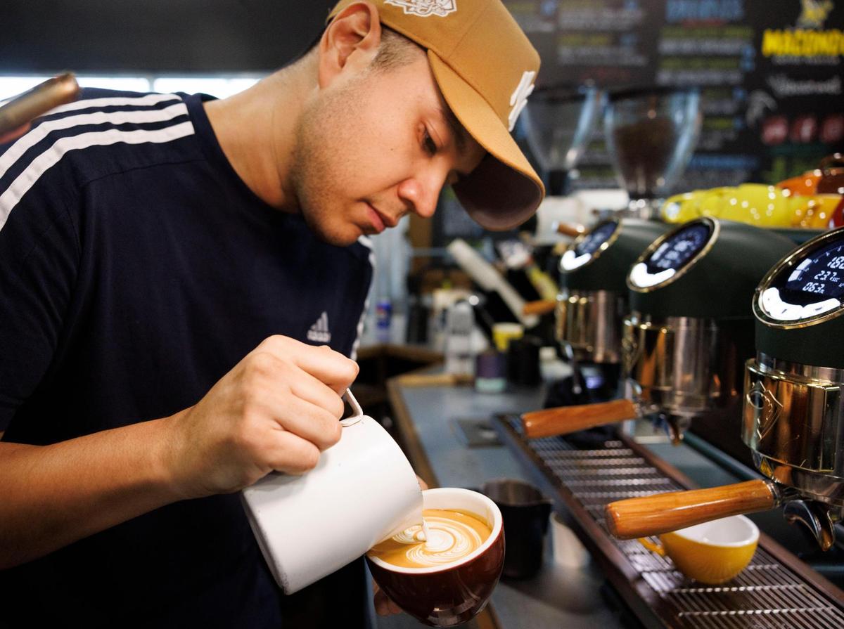 Didier Higuita, a fourth generation coffee grower from Colombia, makes coffee art in a latte during the morning on Tuesday, Feb. 18, 2025, at Macondo Coffee in Doral, Fla. Higuita started working seasonally at Macondo in 2017 while he was still working in coffee in Colombia and moved here to work full time in 2022.