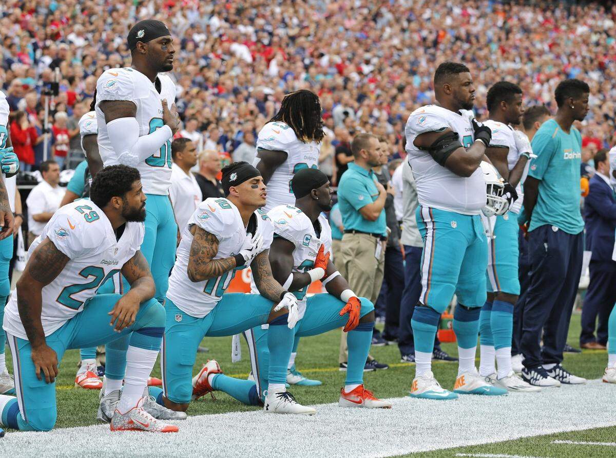 Miami Dolphins Aaron Foster (29), wide receiver Kenny Stills (10) and free safety Michael Thomas (31) take a knee during the National Anthem before the game as the New England Patriots host the Miami Dolphins at Gillette Stadium on Sunday, Sept. 18, 2016.