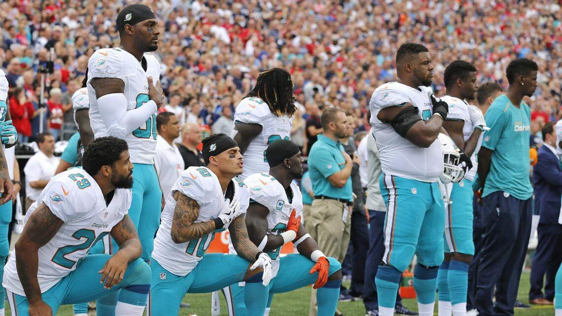 Miami Dolphins Aaron Foster (29), wide receiver Kenny Stills (10) and free safety Michael Thomas (31) take a knee during the National Anthem before the game as the New England Patriots host the Miami Dolphins at Gillette Stadium on Sunday, Sept. 18, 2016.