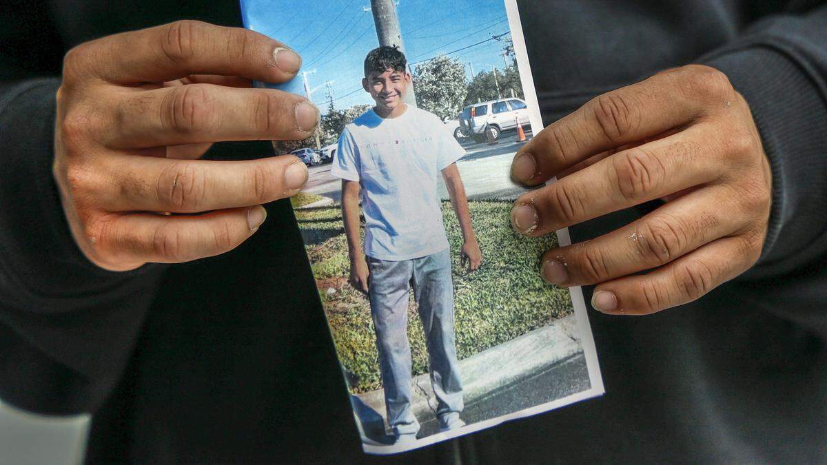 Gabriel Hernandez Alvarez, 19, holds a photograph of himself when he arrived in the U.S. as an unaccompanied minor from Honduras in 2020 when he was 15