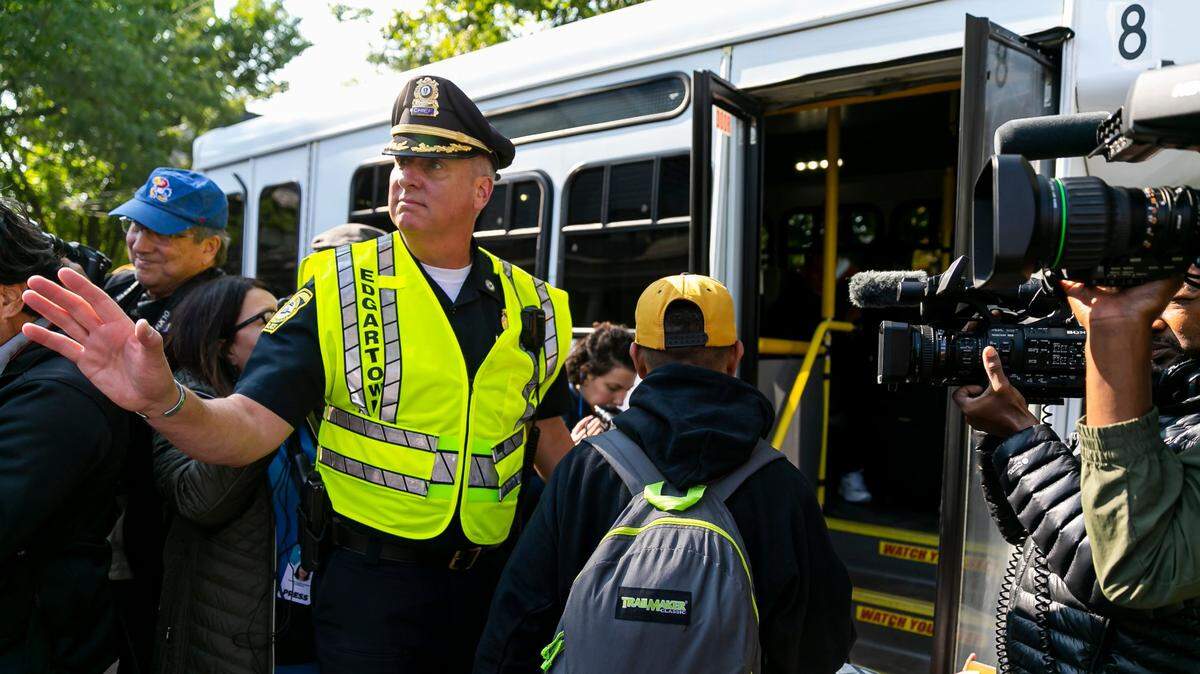 Edgartown Chief of Police Bruce R. McNamee helps Venezuelan migrants onto a bus at St. Andrews Episcopal Church on Sept. 16, 2022, in Edgartown, Mass., on the island of Martha’s Vineyard.