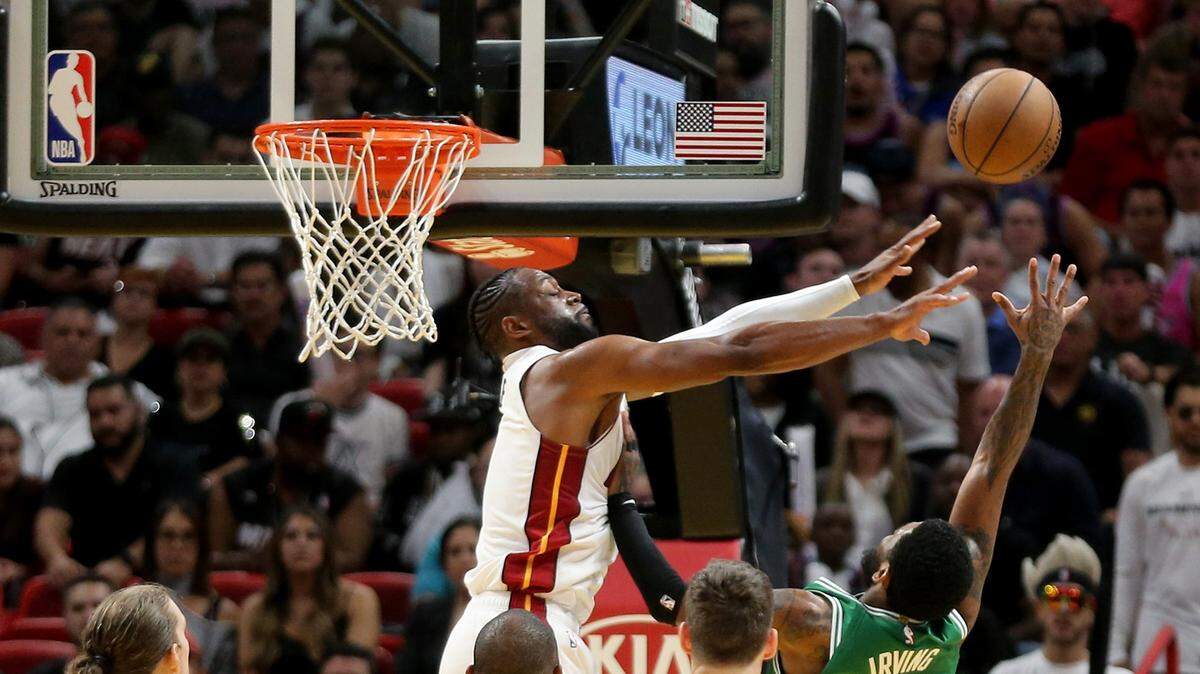 El escolta del Heat Dwyane Wade (3) le pone un tapón al armador de los Celtics Kyrie Irving (11) el miércoles en el AmericanAirlines Arena.