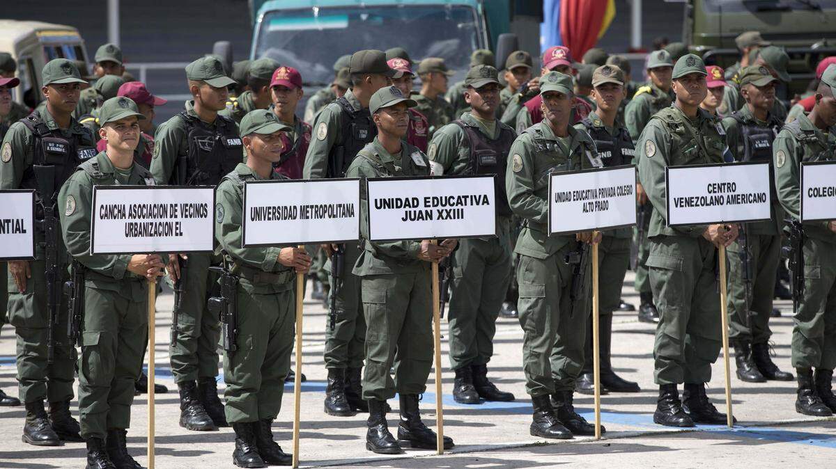 Soldiers hold signs with the names of schools that will serve as voting centers before being dispatched to those locations, at the Military Academy in Caracas, Venezuela, Tuesday, May 15, 2018. About 300,000 soldiers are in charge of security and logistics for the May 20 presidential election.