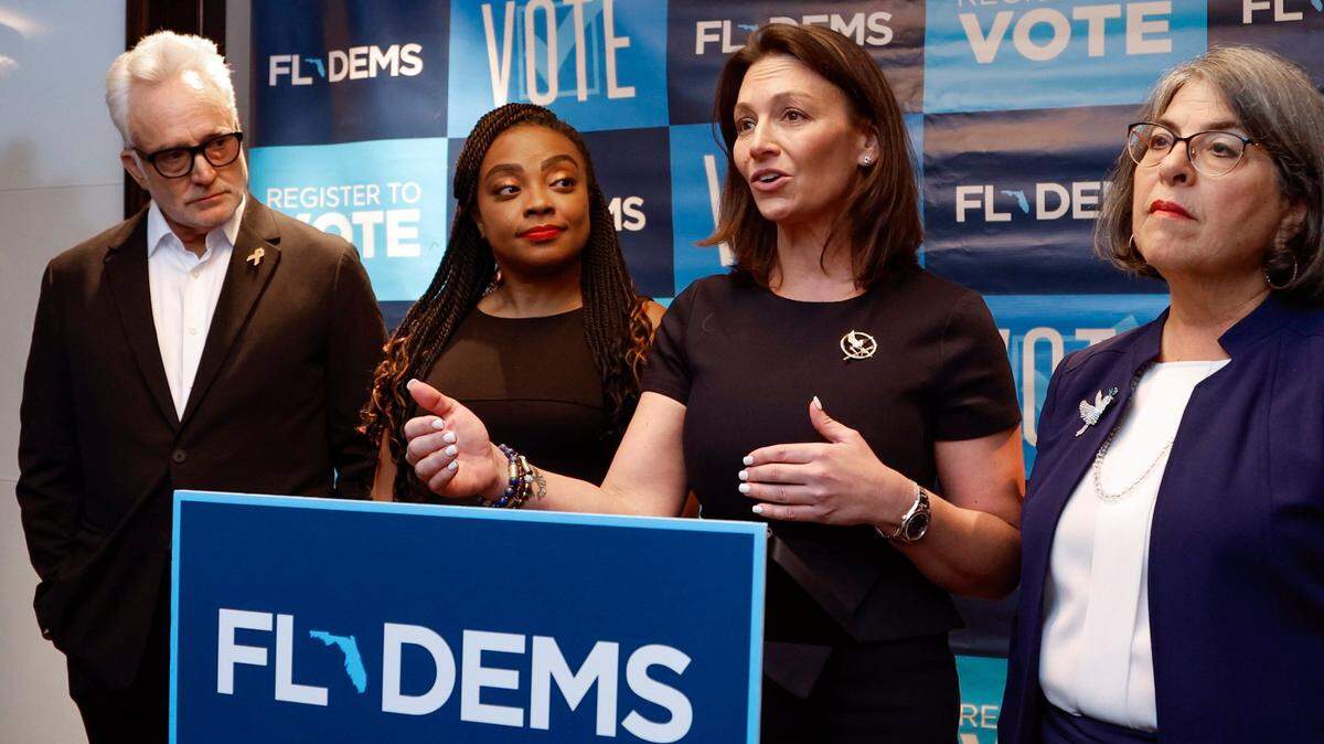 La presidenta del Partido Demócrata de la Florida, Nikki Fried, habla con los periodistas en una conferencia de prensa del fin de semana anual del Partido Demócrata de la Florida en el Hotel Fontainebleau  en Miami Beach el 8 de julio de 2023. La acompañan en el podio el actor y productor Bradley Whitford, la representante estatal Dotie Joseph y la alcaldesa Daniella Levine Cava.