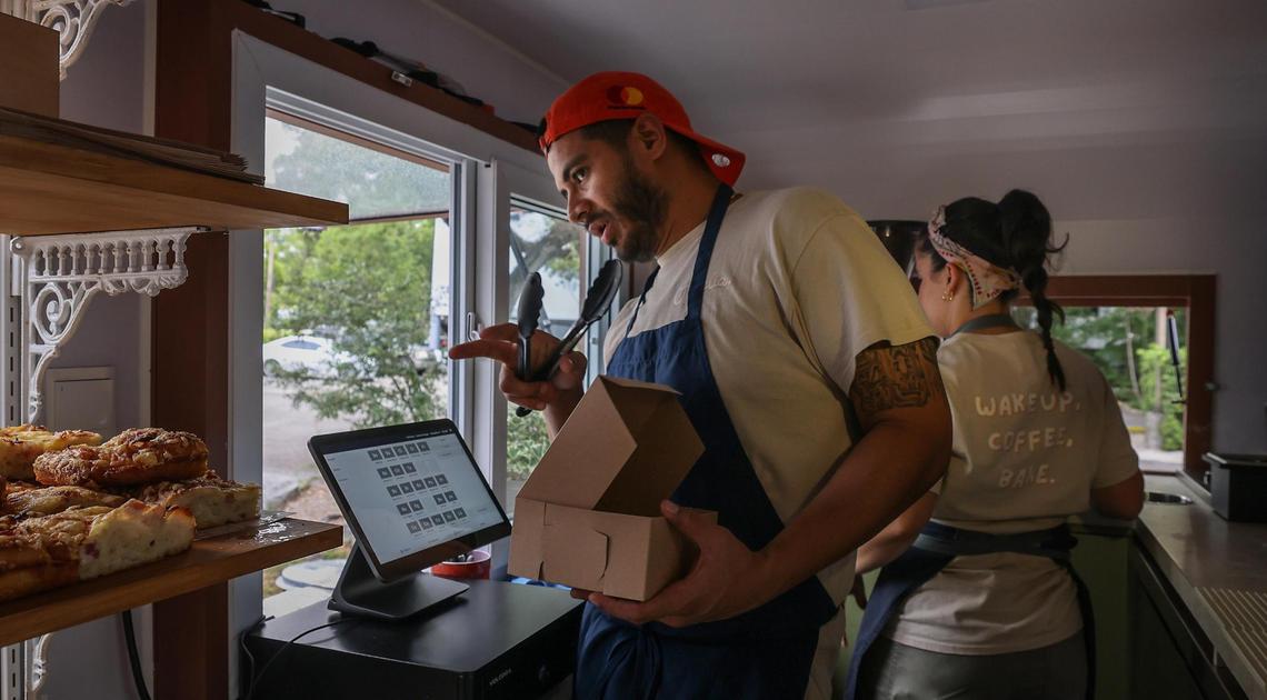Juan Viera takes an order while Ana De Sa Martins handles coffee orders inside Ophelia, their bakery in an RV.